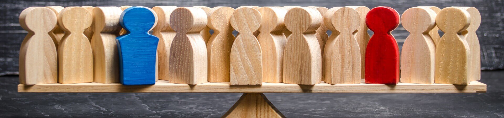 Carved wooden figures on a platform, balancing on top of a wooden pyramid