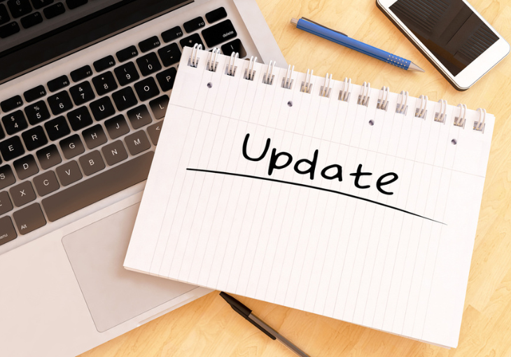 notepad on top of a laptop with Update underlined
